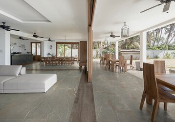 Dlažba imitace kamene Pietra pure piasentina barva hnědá s žilkou na podlaze v obývacím pokoji a na kryté terase